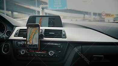 Close up on screen navigation tracking vehicle location and route while driving on road. GPS navigation on smartphone
