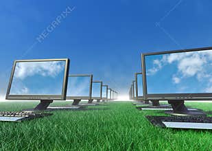 Row of computers in a field of grass.