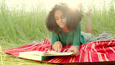 Young girl lying on cover and reading