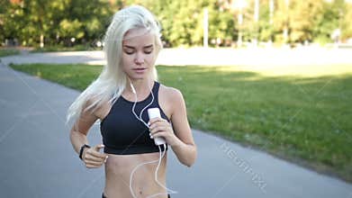 Fitness girl with a smartphone, enjoys sports training, gym workout and listening music