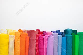 Rolls of bright colored fabric on a white background.