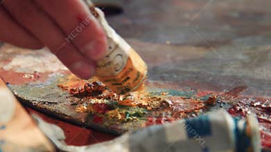 Close up details of yellow oil paint on an artists pallet