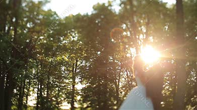 Lovely wedding couple softly kissing in the forest. Beautiful sunset on background. Charming moment