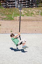 A boy is playing with rope swing on playground
