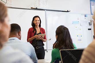 Teacher with tablet and students at an adult education class