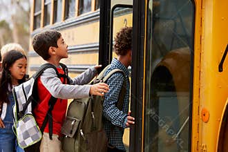 Elementary school kids climbing on to a school bus