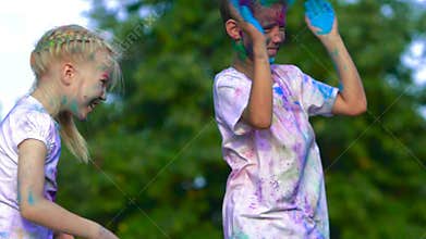 Young children having fun and throwing colorful holy powder at each other