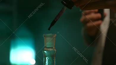 Strange scientist dripping drops of liquid in a flask