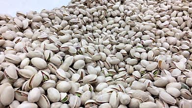 Woman`s hand picking California roasted pistachios at bulk foods section