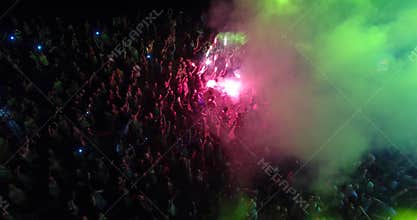 Aerial view of crowd with red signal flare dancing on music festival