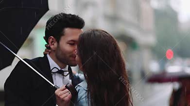 Young handsome bearded man in an elegant costume and tiny attractive woman in casual wear with cornflower bouquet. Young