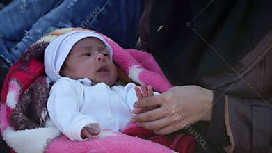 LESVOS, GREECE - NOV 5, 2015: Refugees on the beach. Arab woman with baby.