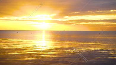 Tranquil scene cloudy sea sunset with seagulls flying and floating on the water at sunset.