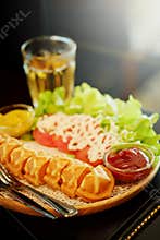 Waffle hot dog stick set with salad and hot tea on table