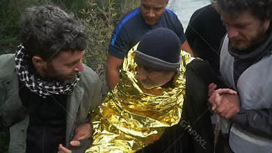 LESVOS, GREECE - NOV 5, 2015: Volunteers help old refugee to go on shore.