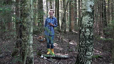 Smiling lost mushroom picker woman holding cellphone with gps in forest