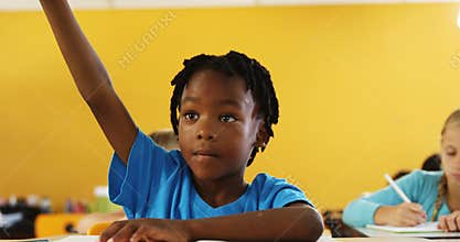 Boy raising hand in classroom