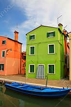 Colorful house by canal in Burano, Venice, Italy.