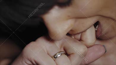 Extreme close up of woman biting her finger because of pain