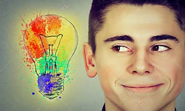 Man with bright idea light bulb looking sideways smiling