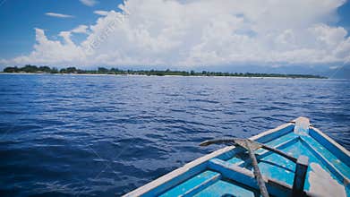 View of the front of the boat with metal anchor is moving rapidly into the distance in ocean. Blue salt water and