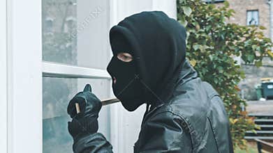 Burglar with crowbar break door to enter the house