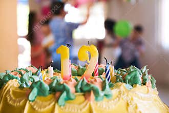 Cake With 12 Candles And Children At Birthday Party