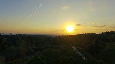 Aerial shot of sunset over forests and mountains