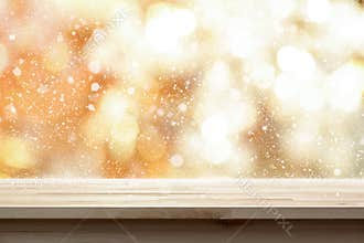 Wood table top on shiny gold bokeh abstract background with snow