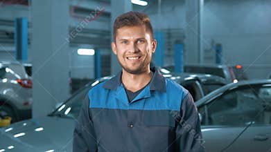 Portrait of Professional smiling car mechanic working in modern auto repair service
