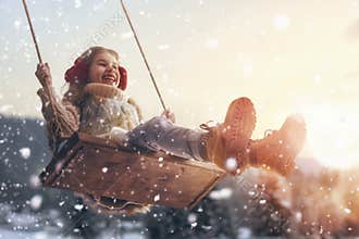 Girl on swing in sunset winter