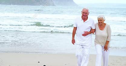 Happy senior couple walking on the beach
