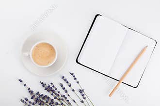 Coffee, clean notebook and lavender flower on white table from above. Woman working desk. Cozy breakfast. Mockup. Flat lay style.