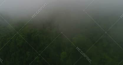 Flying over the high mountains in beautiful clouds