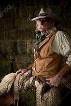 Authentic western cowboy with leather vest, cowboy hat and scarf portrait