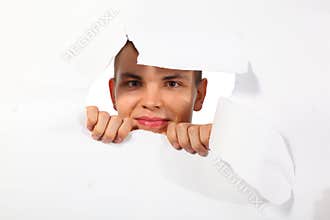 Young man looking out in hole in paper