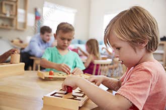 Female Pupil Working At Table In Montessori School