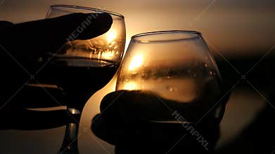 Two wine glasses in the background of a beautiful golden sunset with delicious drinks. slow motion. 1920x1080. full hd