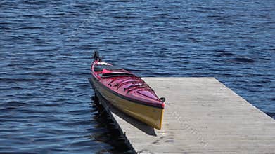 Kayak rests on a wooden pier on the lake