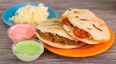 Traditional delicious arepas, shredded chicken avocado and cheddar cheese and shredded beef with grated cheese, avocado