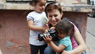 Children play with a girl photographer