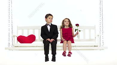 Children ride on a swing, they have a romantic relationship. White background. Slow motion