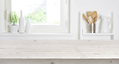 Wooden table on blurred background of kitchen window and shelves