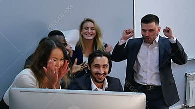 Surprised young business people looking at computer monitor in office