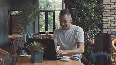 Handsome crazy emotional young happy male guy businessman shows success in cosy cafe. Man work on compter, smiling in
