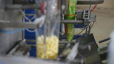 Packaging machine at workshop of food factory Process of packaging candy in foil package Factory worker Automated