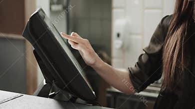 Woman waiter swiping credit card through the computer terminal in cafe and choose