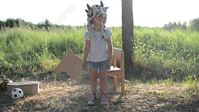 Kid in funny animal hat playing with wooden toy horse