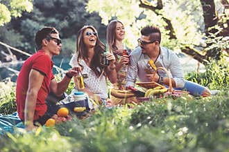 Young people having picnic near the river.