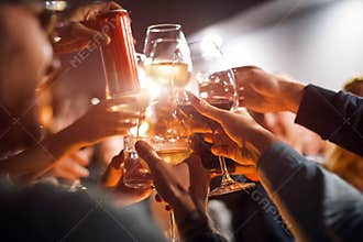 Cheerful friends clinking glasses above dinner table. Alcohol and toasting, party and celebration theme. Congratulations